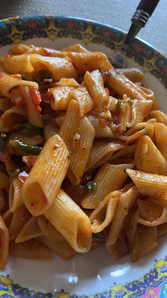 "A plate of delicious red sauce pasta garnished with fresh basil."